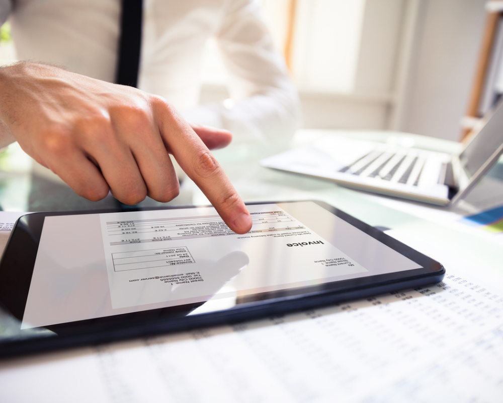 Businessperson Analysing Invoice On Digital Tablet