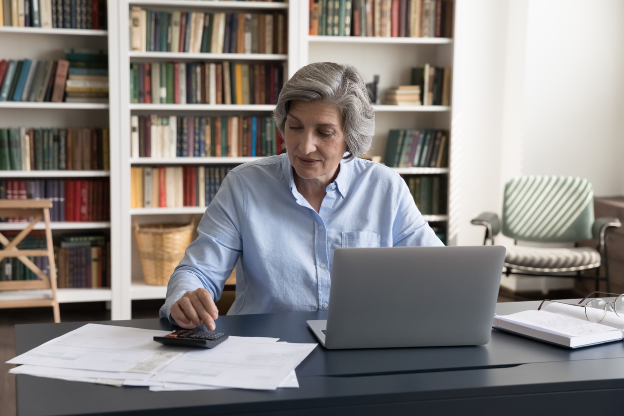 Accountant working seated at workplace desk with laptop