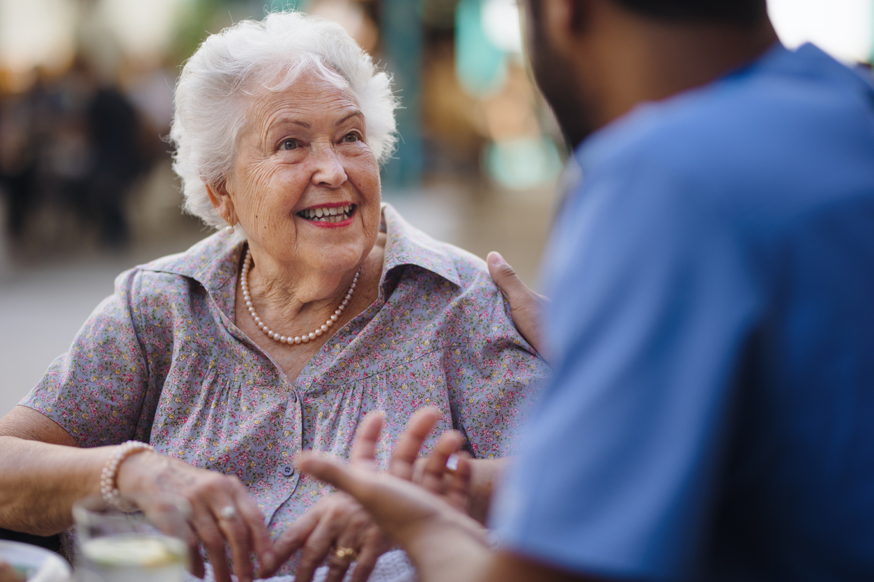 Caregiver talking with his client at cafe, having nice time together