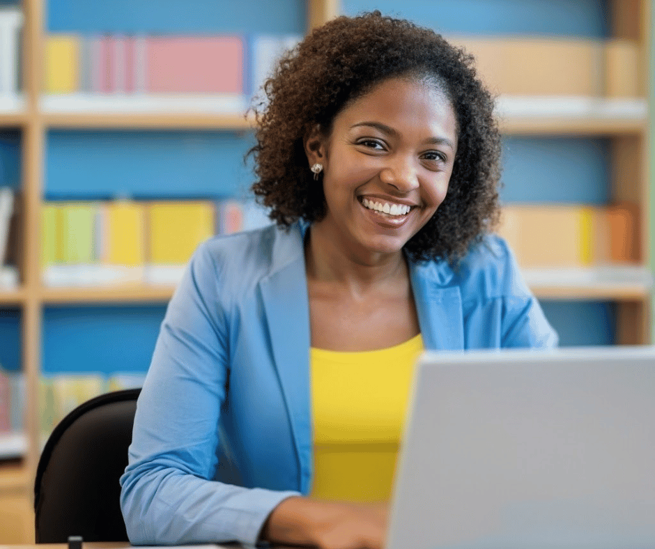 A finance professional working in a school office at a laptop