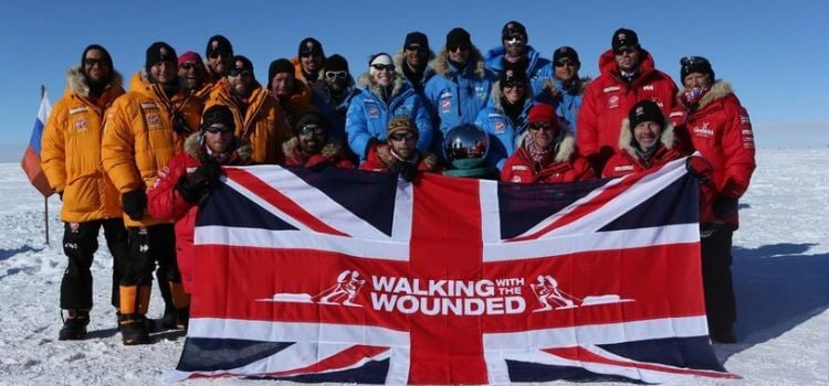 A group of volunteers with a walking with the wounded flag at the south pole